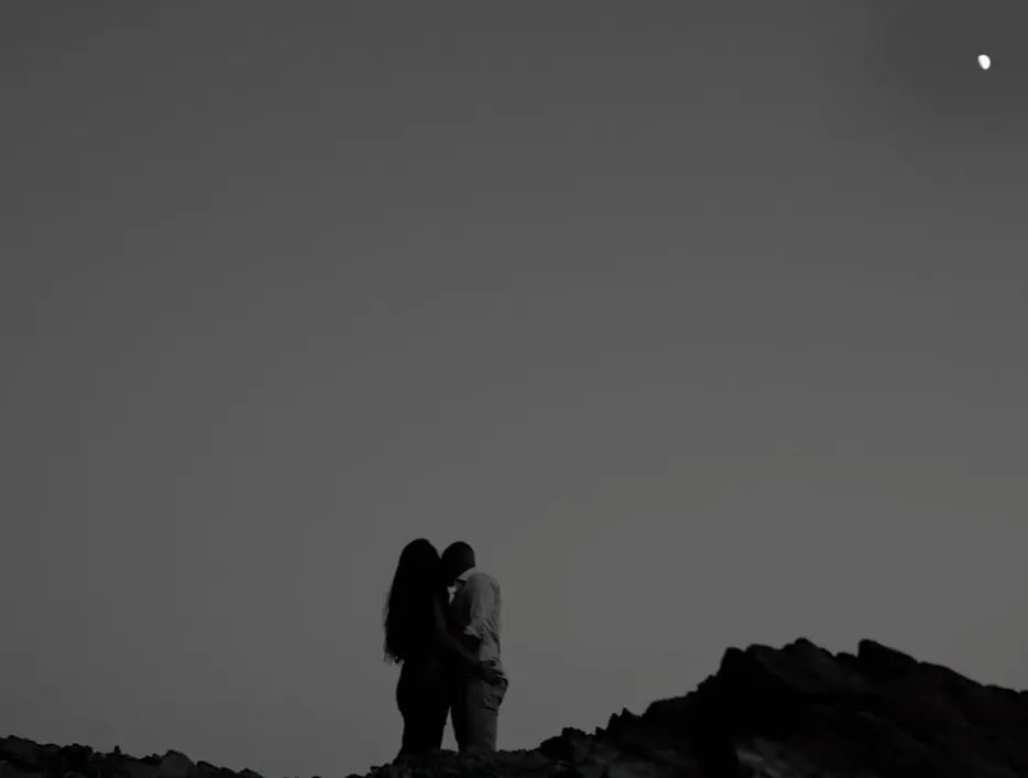 Pareja a contraluz al anochecer bajo la luna