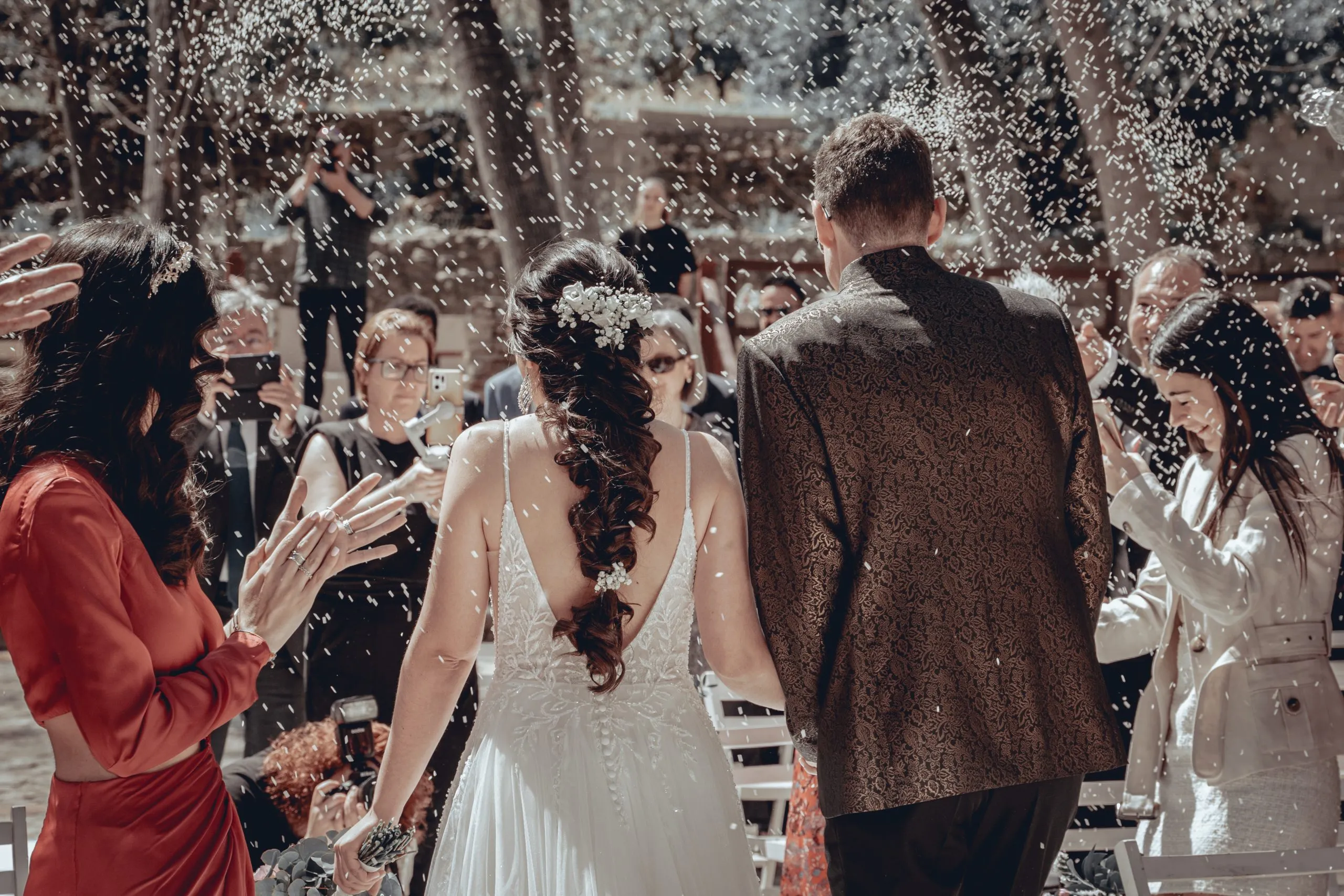 Pareja saliendo de la ceremonia entre arroz