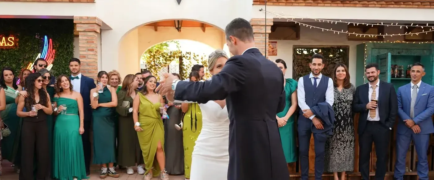 Guests lined up under the arches of a finca as the bride and groom arrive