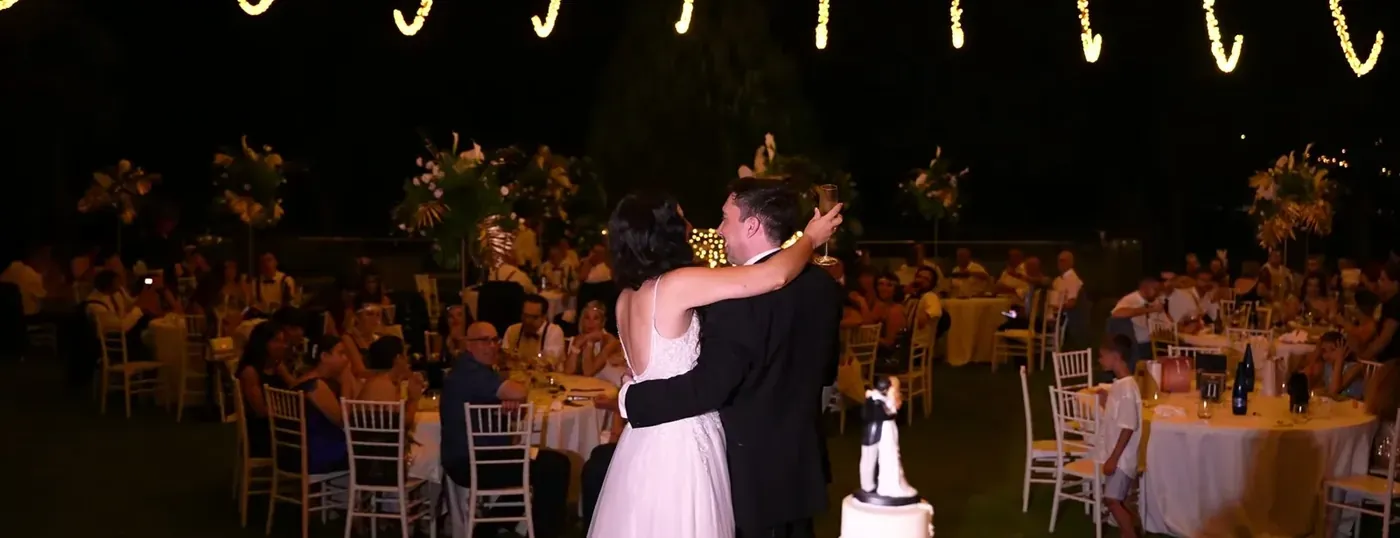 Bride and groom sharing their first dance among the dinner tables under the night sky