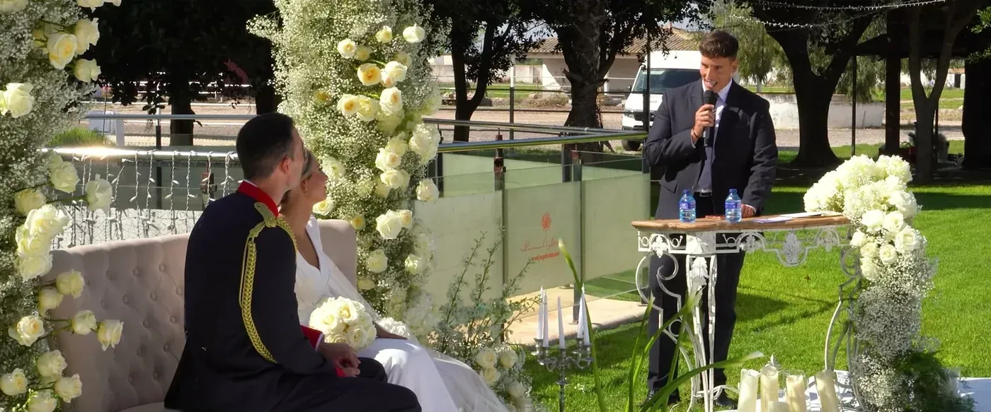A friend officiating an outdoor wedding ceremony from a lectern
